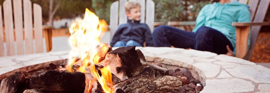 Vater und Sohn sitzen an einer brennenden Feuerstelle